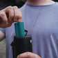 Person pulling a blue swappable battery from a black portable speaker.